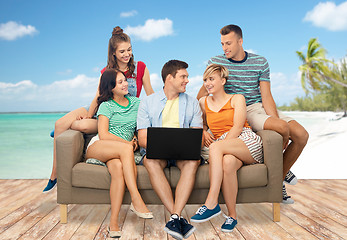 Image showing friends with laptop sitting on sofa over beach