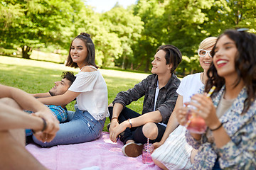 Image showing happy friends with drinks at picnic in summer park