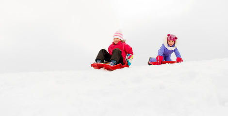 Image showing girls sliding on sleds down snow hill in winter