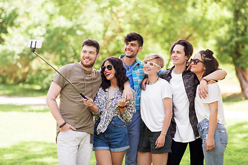 Image showing friends taking picture by selfie stick at summer