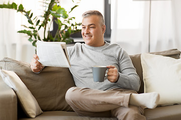 Image showing man reading newspaper and drinking coffee at home