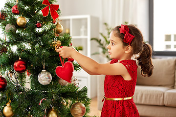 Image showing little girl decorating christmas tree at home