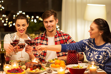 Image showing happy friends drinking red wine at christmas party