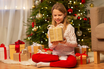 Image showing smiling girl with christmas gift at home