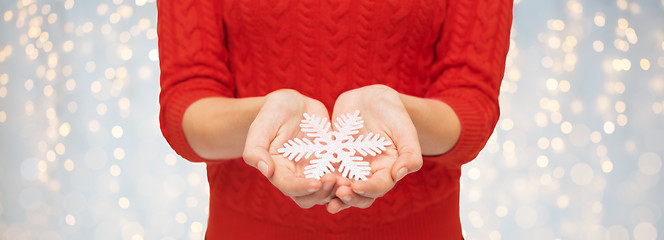 Image showing close up of woman in red sweater holding snowflake