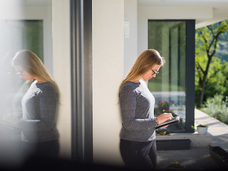 Image showing women using tablet computer in front of luxury home villa