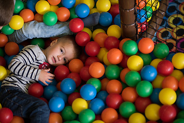 Image showing boy having fun in hundreds of colorful plastic balls