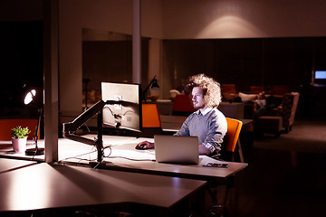 Image showing man working on computer in dark office