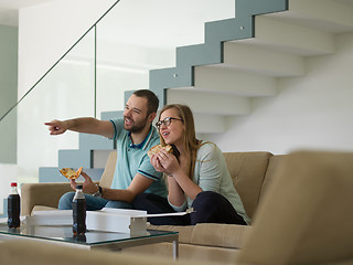 Image showing couple eating pizza in their luxury home villa