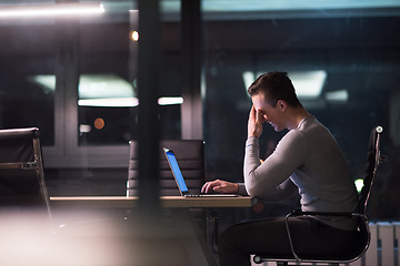 Image showing man working on laptop in dark office