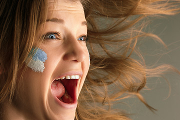 Image showing Portrait of a woman with the flag of the Argentina painted on her face.