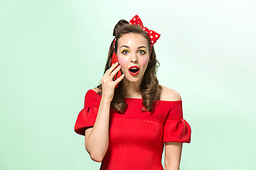 Image showing Beautiful young woman with pinup make-up and hairstyle. Studio shot on white background