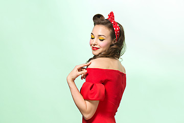 Image showing Beautiful young woman with pinup make-up and hairstyle. Studio shot on white background