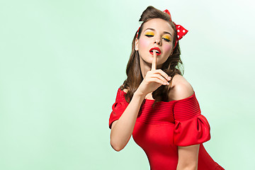 Image showing Beautiful young woman with pinup make-up and hairstyle. Studio shot on white background