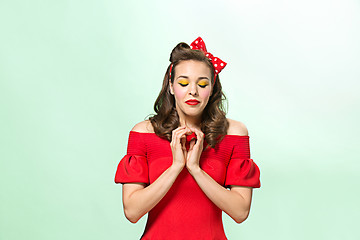 Image showing Beautiful young woman with pinup make-up and hairstyle. Studio shot on white background