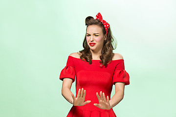 Image showing Beautiful young woman with pinup make-up and hairstyle. Studio shot on white background