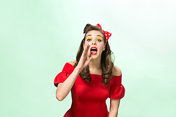 Image showing Beautiful young woman with pinup make-up and hairstyle. Studio shot on white background