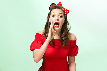 Image showing Beautiful young woman with pinup make-up and hairstyle. Studio shot on white background