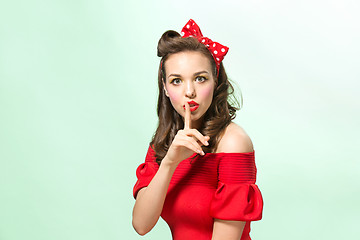 Image showing Beautiful young woman with pinup make-up and hairstyle. Studio shot on white background