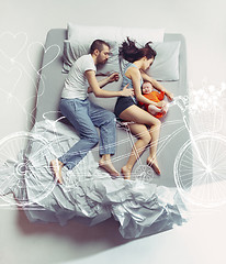 Image showing Top view of happy family with one newborn child in bedroom and their dreams .