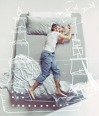 Image showing Top view photo of young man sleeping in a big white bed and his dreams.