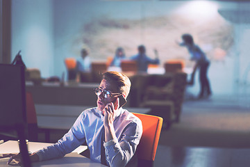 Image showing man using mobile phone in dark office