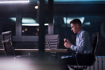 Image showing man working on laptop in dark office