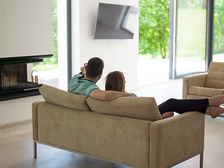 Image showing Young couple on the sofa watching television