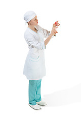 Image showing beautiful young woman doctor in medical robe holding syringe in hand.