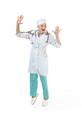 Image showing Beautiful young woman in white coat posing at studio. Full length studio shot isolated on white.