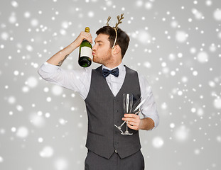 Image showing man kissing bottle of champagne at christmas party