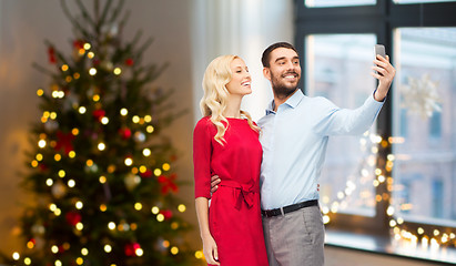 Image showing couple taking selfie by smartphone on christmas