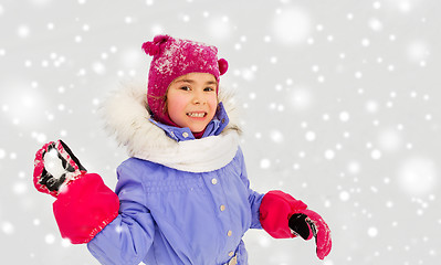 Image showing happy girl playing and throwing snowball in winter