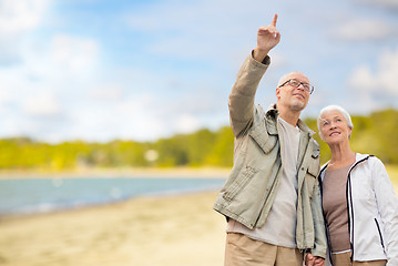 Image showing happy senior couple over beach background