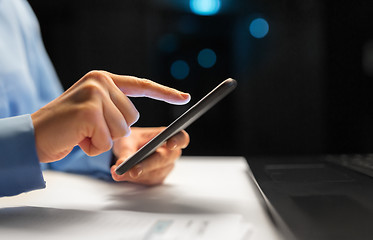 Image showing close up of hands with smartphone at night office