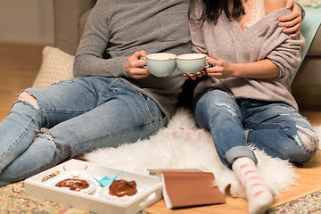 Image showing close up of couple with hot chocolate at home