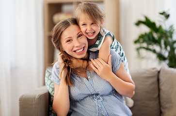 Image showing pregnant mother and daughter hugging at home