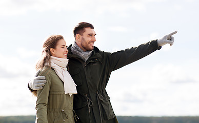 Image showing smiling couple hugging on autumn beach