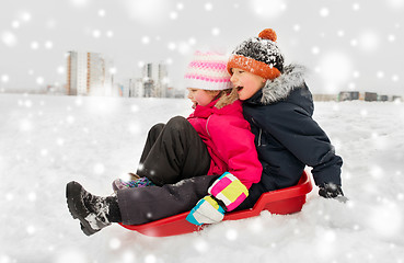 Image showing little kids sliding on sled down hill in winter