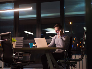 Image showing man working on laptop in dark office