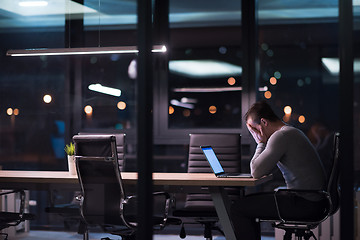 Image showing man working on laptop in dark office