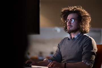 Image showing man working on computer in dark office