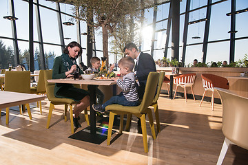 Image showing Young parents enjoying lunch time with their children