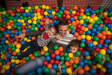 Image showing Young dad with kids in a children\'s playroom