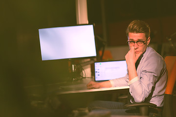 Image showing man working on computer in dark office