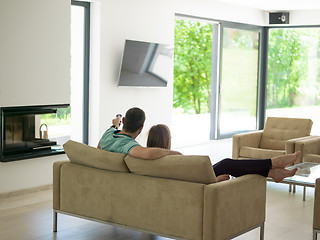 Image showing Young couple on the sofa watching television