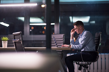 Image showing man working on laptop in dark office