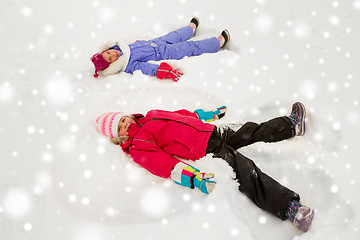 Image showing happy little girls making snow angels in winter