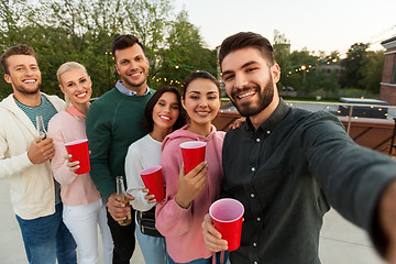 Image showing friends with drinks taking selfie at rooftop party