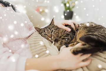 Image showing close up of owner with tabby cat in bed over snow